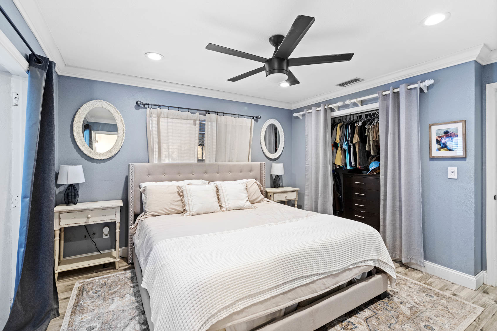 primary bedroom with white bed and blue walls and closet